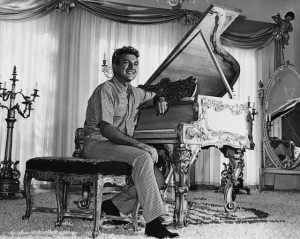 Liberace sitting at a lavishly-decorated gold-leaf piano in the living ...