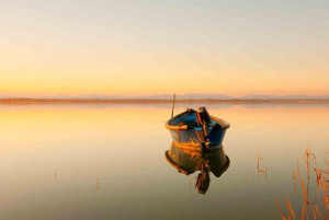 peaceful-water-boat-orange-sunlight-mountains-far-away