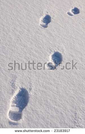 human foot prints in sunny day on the snow - stock photo