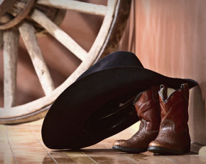 Stock Photo of cowboy hat leaning boots wagon wheel fine art portrait