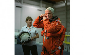 Senator John Glenn checks the communications system on his head gear ...
