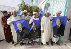 ... Abdelaziz Bouteflika, hold placards of him during a rally meeting in