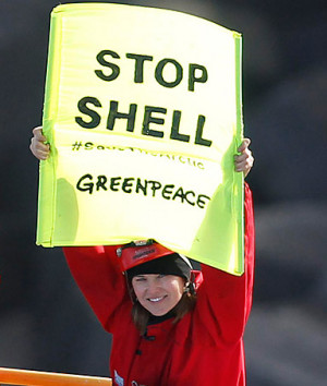 Actress Lucy Lawless and a Greenpeace activist hold up banners on the ...