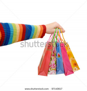 Women's hand in a rainbow colorful dress holding some shopping bags as ...