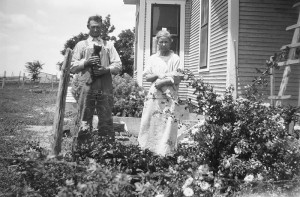 Will and Caroline Henderson stand next to their house, holding cats ...