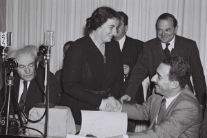 Golda Meir shakes hands with Moshe Sharett after signing Israel’s ...