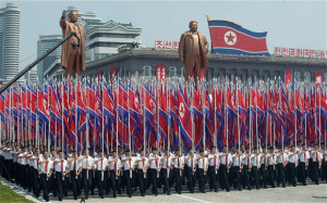 north koreans wave flags and walk with statues of former leaders kim ...