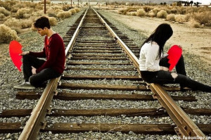 Couple with broken hearts sitting on a track