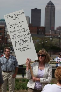 holds a sign with a quote by Margaret Thatcher at a tea party tax ...