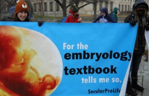 Secular Pro-Life founder Kelsey Hazzard, left, carries a sign at the ...