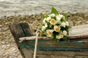 ... of ivory-colored roses set on a boat hull after a beach wedding