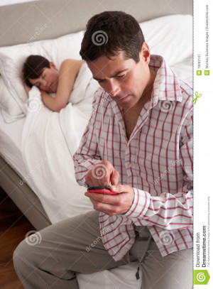 Suspicious Husband Checking Wife's Mobile Phone Whilst She Sleeps.