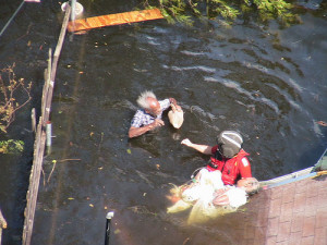 Guard rescue swimmer prepares an elderly man and woman for rescue ...