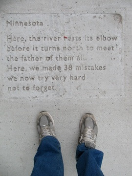 Cement quote on the sidewalk addressing the 38 men who were hung here ...