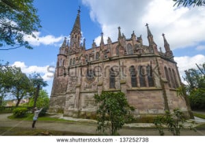 tourist taking a picture of the gothic church of Comillas, Spain ...