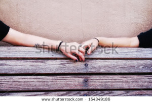 two people holding hands on a bench