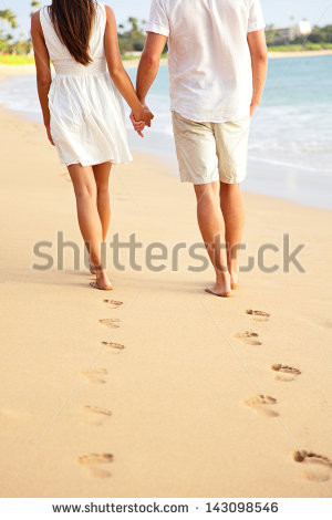 ... feet and golden sand for copy space. Young couple wearing white shorts