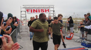 Ben Baltz is carried across the finish line by Pfc. Matthew Morgan, a ...