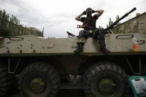 Armed pro-Russian separatist keeps watch from an armoured personnel ...