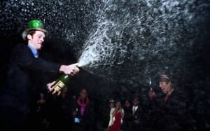 Man spraying champagne at New Years Eve party