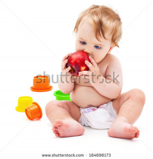 Cute little caucasian boy 11 months old sits and eats red apple on ...