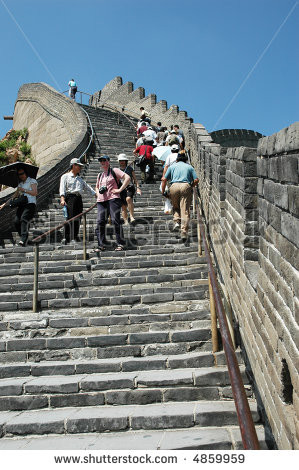 Tourists climbing stairs on the Great Wall of China - stock photo