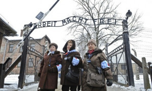 Holocaust survivors walk outside the gate of the Auschwitz Nazi death ...