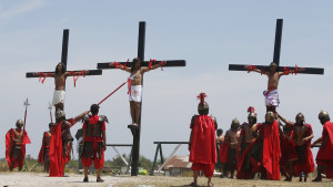 crosses during the re-enactment of the crucifixion of Jesus Christ ...