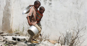 Two Somali children walk to a food distribution center