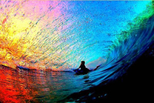 Preciosa ola de surf en medio del arco iris