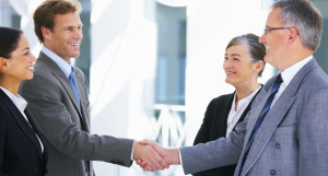 Photo of business men and women shaking hands