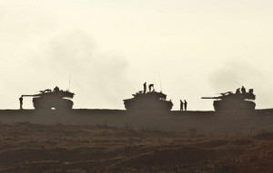 Israeli soldiers are silhouetted next to their tanks during a during a ...