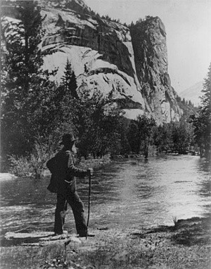 John Muir standing beside the Merced River, Yosemite