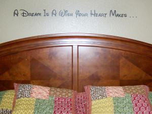 ... wall quotation above the bed's headboard with pillows on the bed