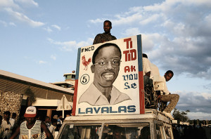 up a sign for Haitian presidential candidate Jean-Bertrand Aristide ...