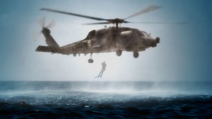 US Navy Aviation Rescue Swimmer jumps from Navy helicopter into water.