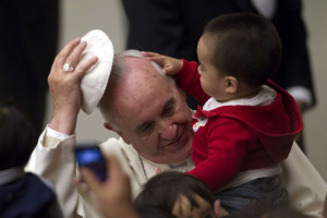 Pope Francis has his skull cap removed by a child during an audience ...