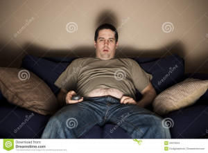 Overweight slob watches TV with belly showing.