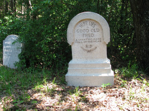 Hidden on the right, the tombstone reads: 