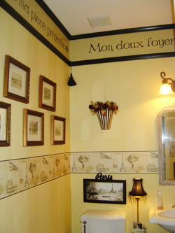 french wall quote in the toilet room with picture frames on the left ...