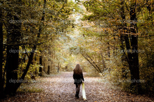 Sad woman walking alone in the woods - Stock Image