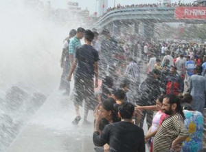 ... get drenched by a large wave during high tide at sea front in Mumbai