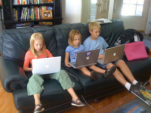 melinda and bill gates children using laptop on sofa