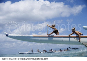... Waikiki Women paddling outrigger canoe in a race Front of boat in air