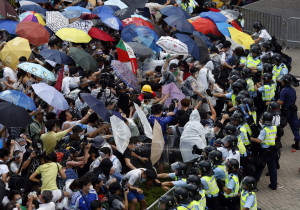 Protesters take cover from pepper spray with umbrellas as riot police ...