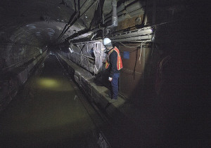 MTA employees work on a flooded New York City subway tunnel following ...