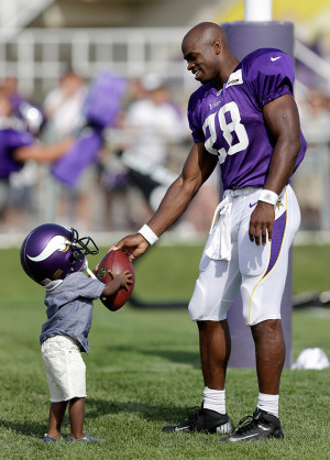 Adrian Peterson hands a football to Adrian Jr. at the end of Vikings ...