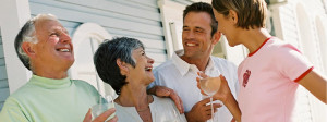 Older couple laughing with younger couple holding wine glasses