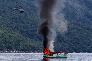 Indonesian forces sink a Vietnamese fishing boat, December 2014. Photo ...