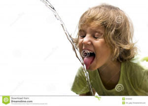 Thirsty little girl trying to catch the water jet with her tongue.
